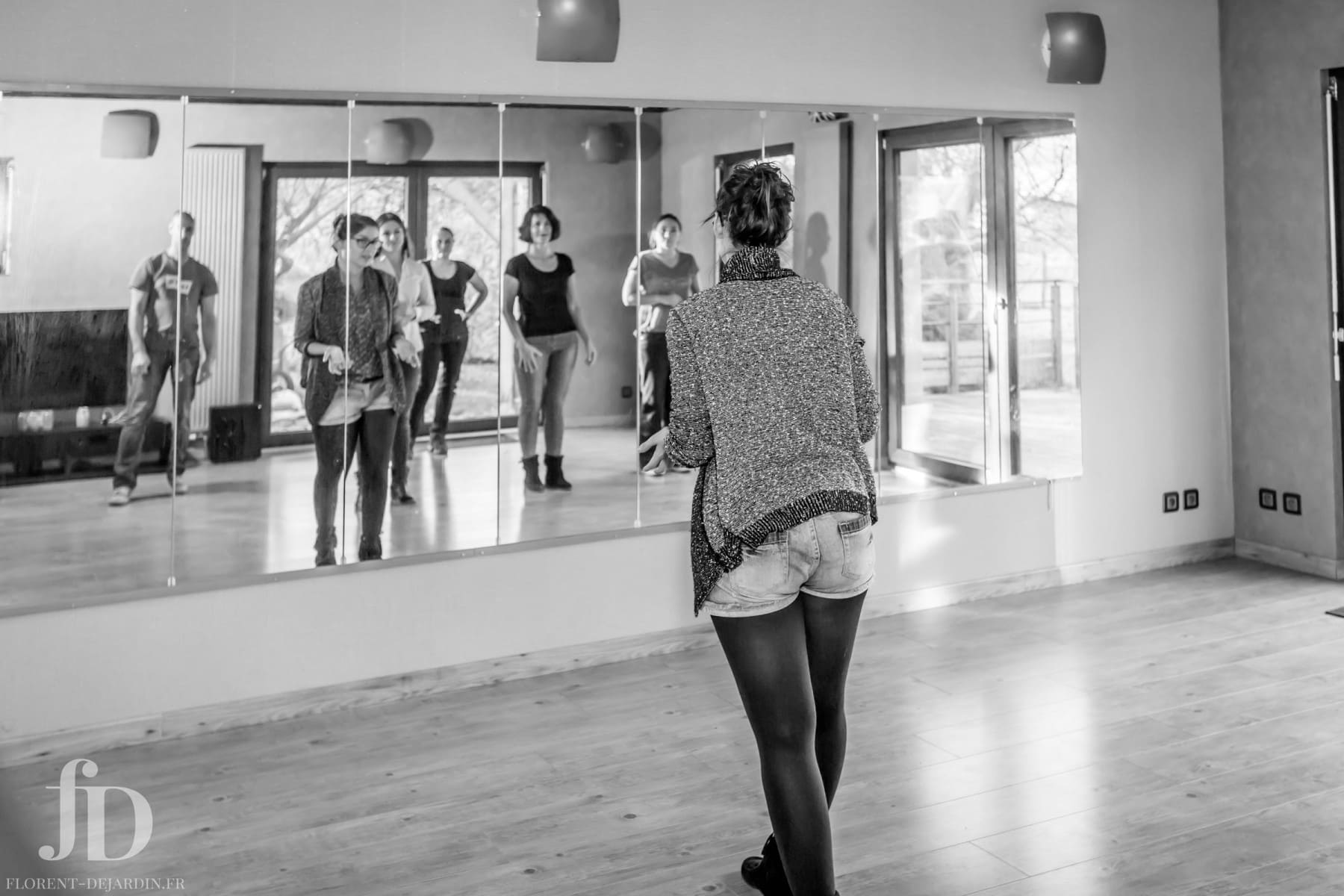Atelier technique solo en danse face au miroir, travail d’appropriation du mouvement et précision corporelle en groupe.